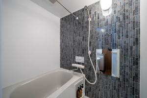a bathroom with a bath tub and a mirror at LudiCent717 - Vacation STAY 08159v in Toyohira +15 photos
