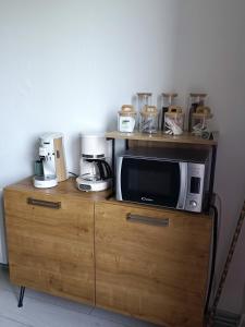 a microwave sitting on top of a wooden cabinet at appartement cosy parking privé in Chazey-sur-Ain