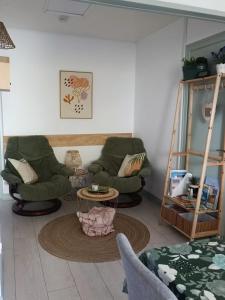 a living room with two chairs and a table at appartement cosy parking privé in Chazey-sur-Ain +18 photos