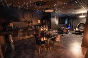 a dining room with a table and chairs and a kitchen at Suite Chic - Antre-parenthèse in Gravelines
