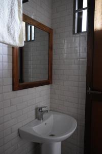 a white bathroom with a sink and a mirror at New Dream House in Arusha