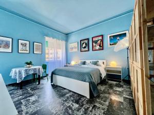 a blue bedroom with a bed and a table at Apartment Sonnino 37 in Cagliari