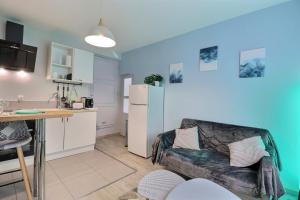 a living room with a couch and a kitchen at Les Apparts du Pont Vert - lit double - WiFi - tout inclus - 5 in Troyes