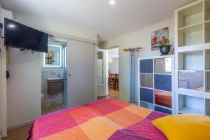 谢尔河畔塞勒La Salamandre - maison avec jacuzzi的一间卧室配有一张色彩缤纷的床和一间浴室。