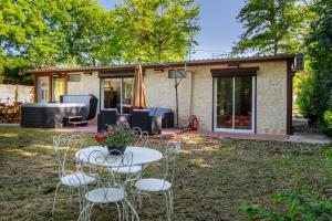 谢尔河畔塞勒La Salamandre - maison avec jacuzzi的房屋前设有带桌椅的天井。