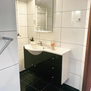 a bathroom with a sink and a mirror at Dom nad Jeziorem in Sajzy +28 photos