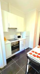 a kitchen with white cabinets and a stove and refrigerator at NEGURI 5 y 3 Garden Metro y Playa in Getxo