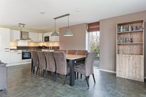 una cucina con tavolo da pranzo e sedie di Oude Nieuwelandseweg 33B - Ouddorp - Villa Hopper met jacuzzi, voor gebruik - NOT FOR COMPANIES a Ouddorp