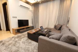 a living room with a couch and a television at Madinaty Gateway Prime Apartment B12 in Madinaty
