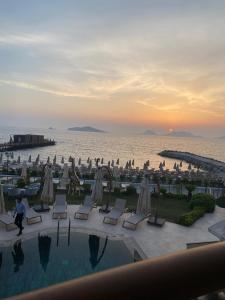 a view of a pool with chairs and the ocean at Small Beach Hotel in Bodrum City