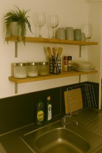 een gootsteen met borden en glazen op planken bij Charming apartment With Private Balcony in Johannesburg