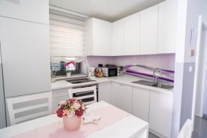 a white kitchen with a vase of flowers on a counter at Apartments Toni in Baška +22 photos