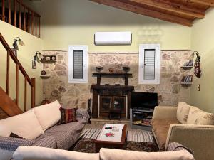 a living room with a fireplace and a stone wall at AgroPhilia in Kourkouloí