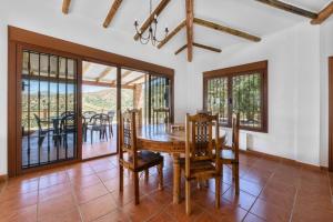 a dining room with a wooden table and chairs at Casa del Molino in Canillas de Aceituno
