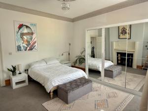 a bedroom with a large bed and a mirror at Entire Apartment by City Centre & Harbourside in Bristol