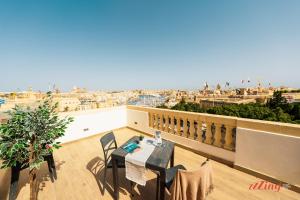 a balcony with a table and a view of the city at Yolanda Boutique Suites by Zzzing in Cospicua