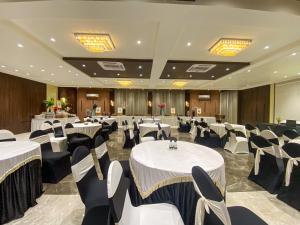 a banquet hall with white tables and chairs at NULIFE in Jamnagar +48 photos