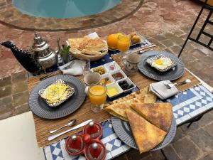 a table with plates of breakfast food on it at Riad Dar Laure in Taroudant
