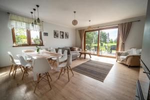una sala de estar con una mesa y sillas en Kiton House, en Skarlin