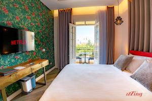 a bedroom with a bed with a television and a desk at Yolanda Boutique Suites by Zzzing in Cospicua