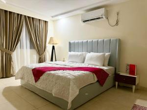 1 Schlafzimmer mit einem Bett und Klimaanlage in der Unterkunft DownTown Apartments Gulberg in Lahore