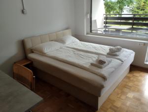 een bed met handdoeken in een kamer met een raam bij Studio Kaninska vas in Bovec