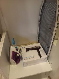 une boîte posée sur une étagère avec une tondeuse à cheveux dans l'établissement Chambre cosy avec jardin à Pattaya, à Jomtien Beach