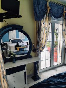 a bedroom with a mirror and a bed and a window at Theros Seaside House - Volos in Marathos