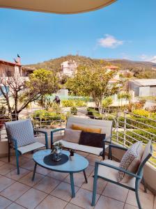 a patio with chairs and tables on a balcony at Theros Seaside House - Volos in Marathos