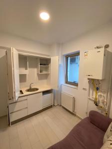 a small kitchen with white cabinets and a sink at White Luxury Apartament in Mamaia Nord