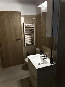 a bathroom with a sink and a toilet and a mirror at White Luxury Apartament in Mamaia Nord