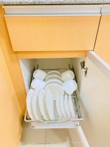 a drawer filled with plates and bowls in a refrigerator at 8 Skyline Sunset Suite in Iloilo City +5 photos