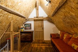 an attic room with a couch and a table at Maison De Vacances Chêne in Auriac-du-Périgord