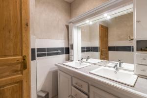 a bathroom with two sinks and a large mirror at Maison De Vacances Chêne in Auriac-du-Périgord +20 photos