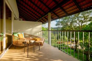 a porch with a couch and a table on a balcony at Gateway Coorg in Madikeri