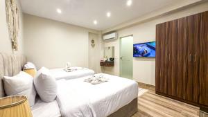 a hotel room with two beds and a tv at Infinity Pyramids Inn in Giza