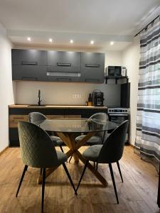 a kitchen with a glass dining table and chairs at Bay House Balaton in Balatonfůzfő +5 photos