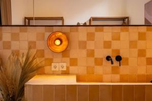 een tegelbalie met een licht op een muur bij Sofia Villa by betterplace in Canggu +25 foto's