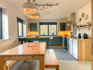 a large kitchen with a wooden table in it at The Piggery near Bruton in Evercreech