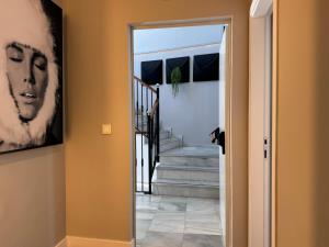 a hallway with a door leading to a stairway with a painting at Hotel Puerta del Mar - Adults Recommended in Nerja