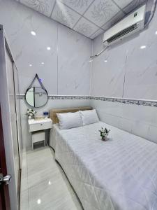 a bedroom with a large white bed and a mirror at Homestay Nằm Tại Bãi Biển - Bao Trọn Căn Nhà Là Biển - View Trực Diện Biển - Homestay Ăn Gì Cũng Được in Vung Tau