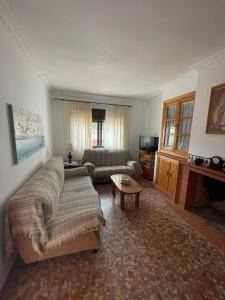 a living room with a couch and a tv at chalet Mazagón in Moguer