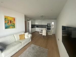 a living room with a white couch and a kitchen at Apartment in Kent Beachfront NEW in Ramsgate