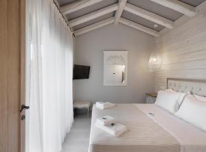 a bedroom with a bed with two towels on it at By the sea luxury suites in Limenas +121 photos