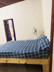 a bed in a room with a blue mattress and a fan at Serene Room and Living Room in Serekunda +3 photos