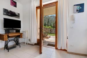 a room with a television and a desk and a door at Appartamento SOLE in Brenzone sul Garda