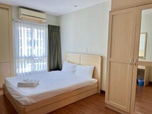 a bedroom with a bed with white sheets and a window at Luxury Villa Patong in Patong Beach