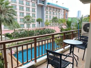 a balcony with a table and chairs and a swimming pool at Luxury Villa Patong in Patong Beach