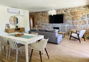 a living room with a couch and a table and chairs at Casa do Sol e Vinho in Ourilhe
