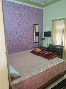 a bedroom with a purple wall with a bed at Hotel Sandeep palace in Jāmb